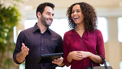 Two people talking inside a Lexus dealership.